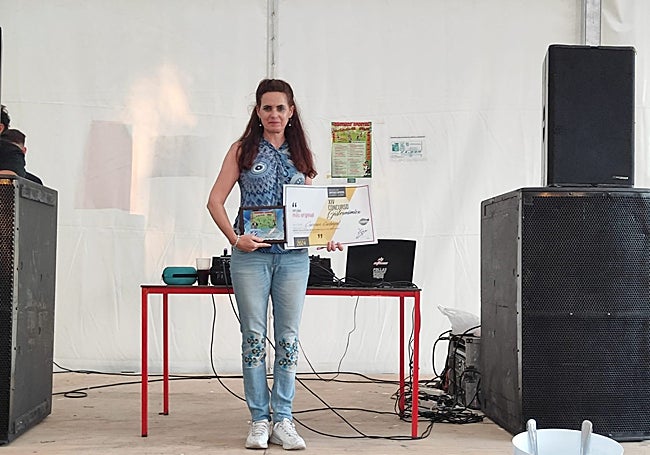 La autora del 'tortichopo' posa sobre el escenario con su diploma y su placa.