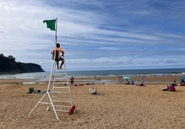 Bandera verde en la playa de Rodiles, ayer, tras la marcha de las carabelas portuguesas.