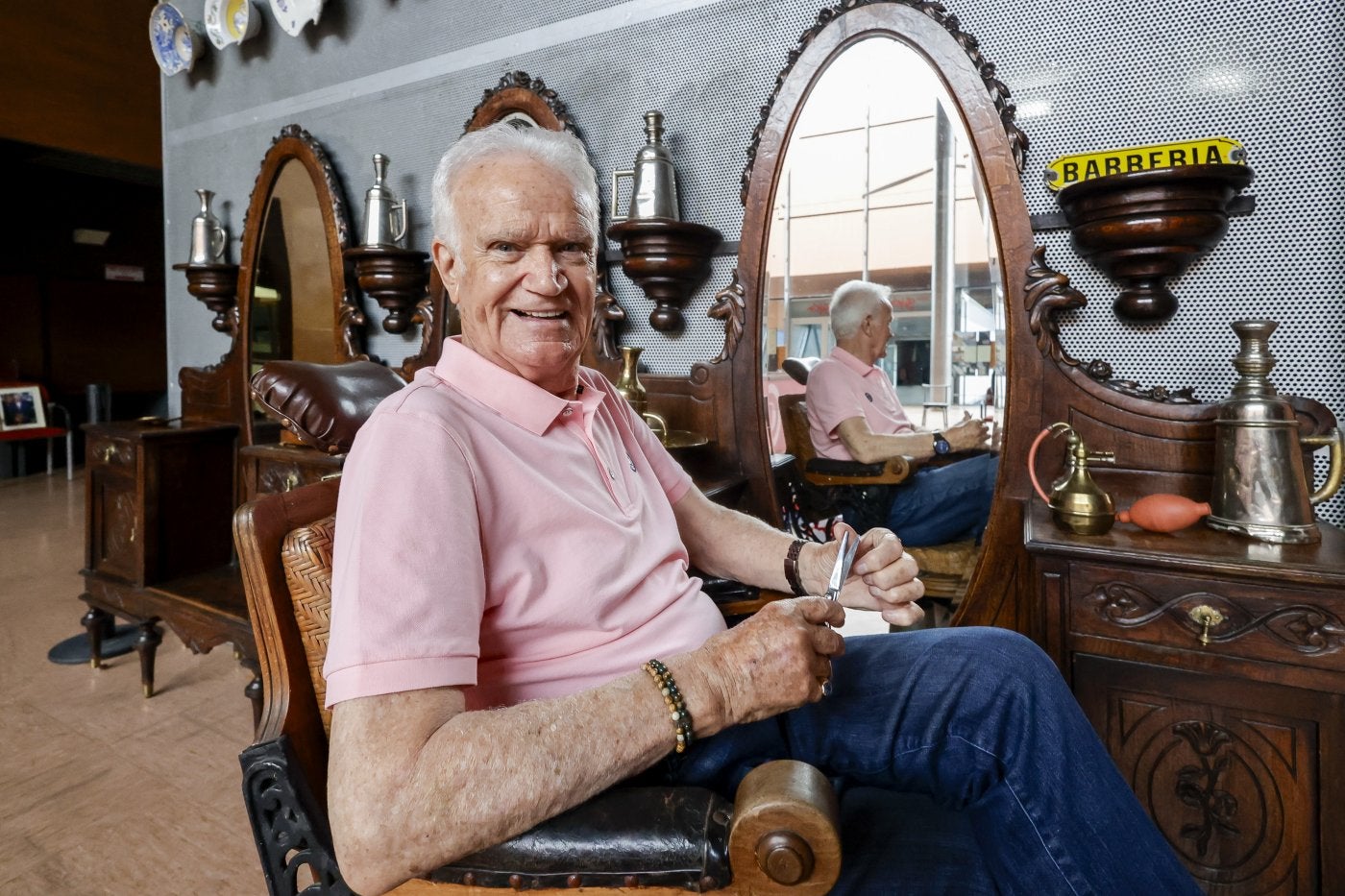 Ramiro Fernández, en una de las sillasde su Museo de la Barbería que exponeen el Palacio de Congresos.
