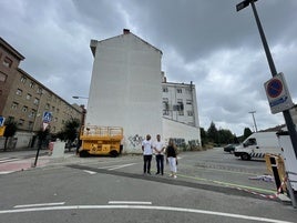 Los ediles Javier Rodríguez y Sonia Lago, con el artista 'Sojo', delante de la pared en la que se pintará el mural.