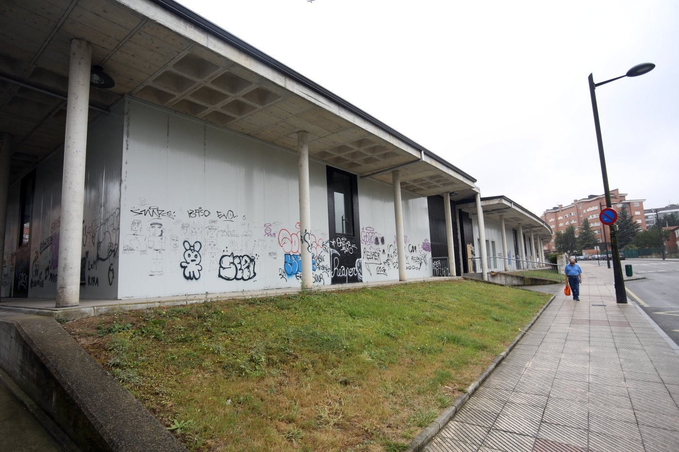 El exterior del mercado de La Corredoria, que se quiere reconvertir en un centro social integrado y actualmente luce cubierto de grafitis.