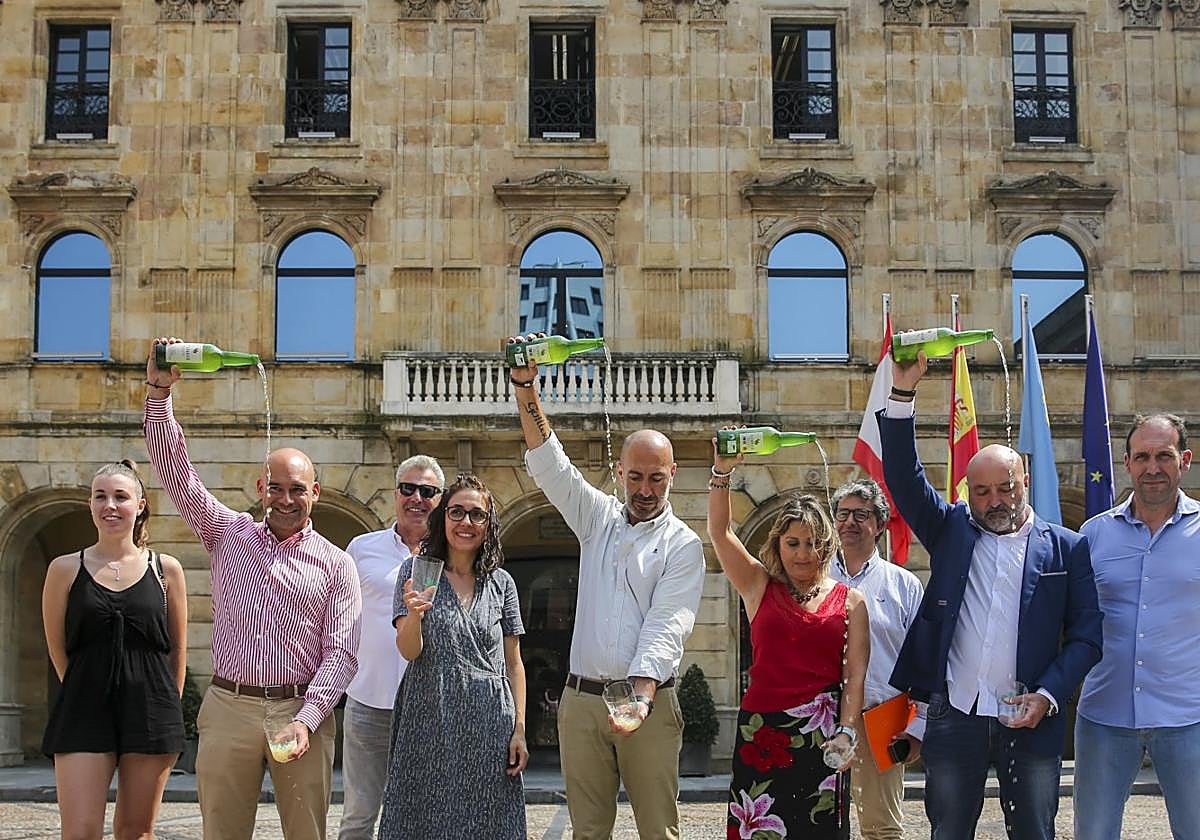 Nerea Tomás (Sidra Jr), Jesús Martínez Salvador, Adolfo Rubio (Sidra Acebal), Raquel Alonso (Asociación Galbán), el presidente de Divertia, Óliver Suárez, Luz Muñiz (Sidra Cabueñes), Fernando Losada (Divertia), el concejal Guzmán Pendás y Gerardo Menéndez (Sidra Menéndez) escancian en la plaza Mayor.