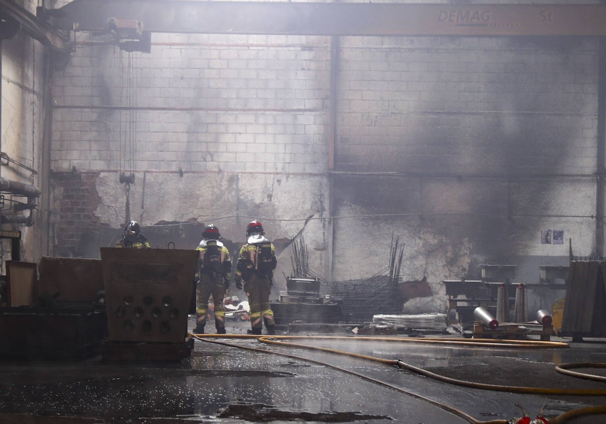 Los bomberos durante las labores de extinción del incendio en la nave del polígono de Bankunión.