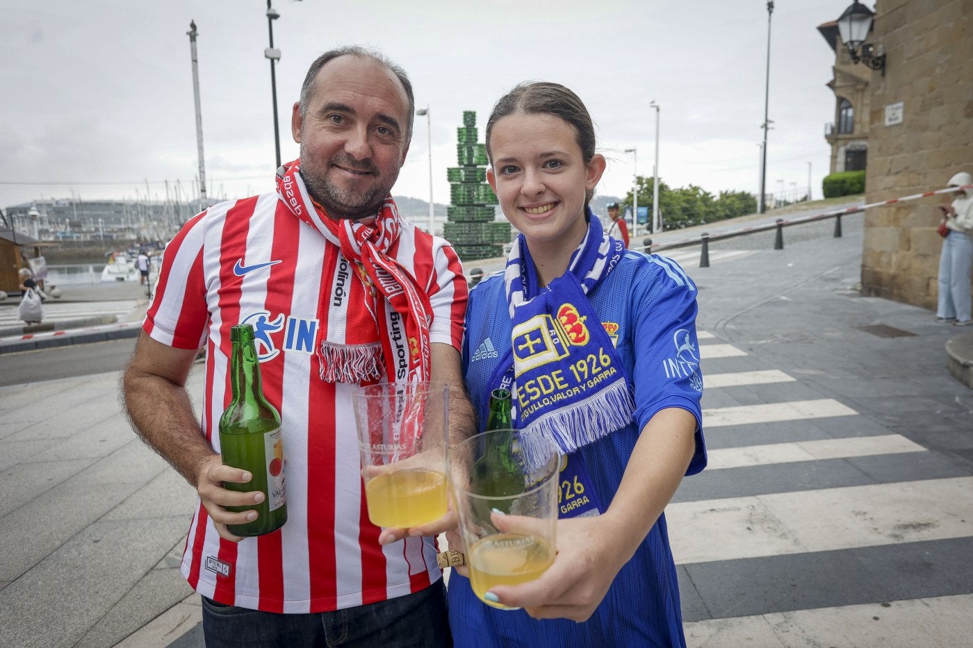 El sportinguista Daniel Carbajal y la oviedista Carla Castrillón ofrecen un culín de sidra antes del derbi.