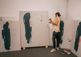 Virginia Rivas trabaja en las pinturas de la exposición.