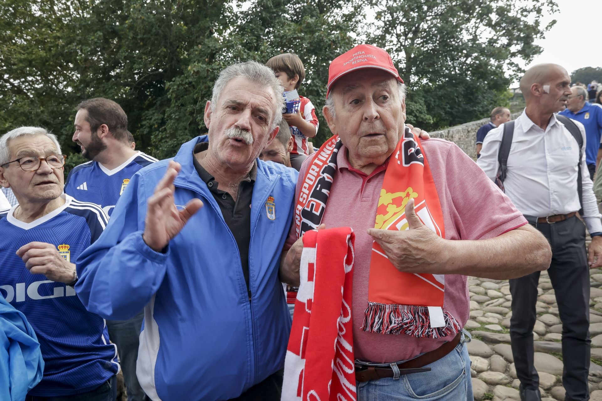 Dos veteranos seguidores de los dos principales asturianos charlan a los pies del Puente Romano.