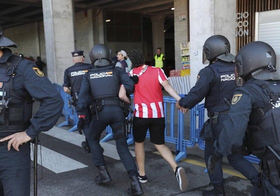 La policía lleva a un aficionado del Sporting al interior de El Molinón.