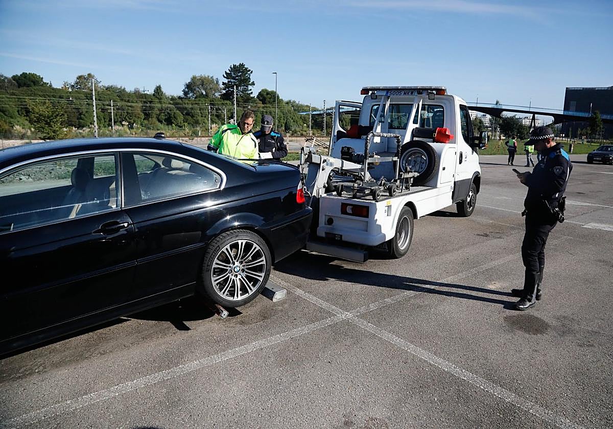 La grúa retira uno de los vehículos estacionados en el parking de la avenida de Portugal tras la denuncia de la Policía Local.