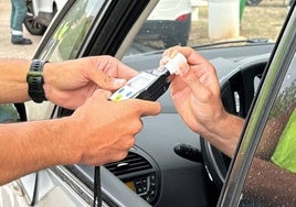 Un agente de la Guardia Civil de Tráfico realiza un control de alcoholemia a un conductor.