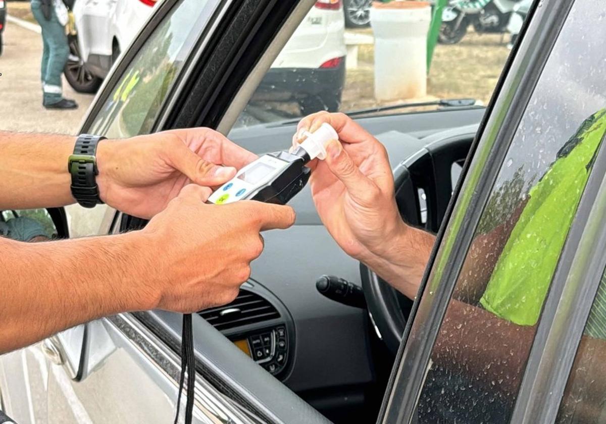 Un agente de la Guardia Civil de Tráfico realiza un control de alcoholemia a un conductor.