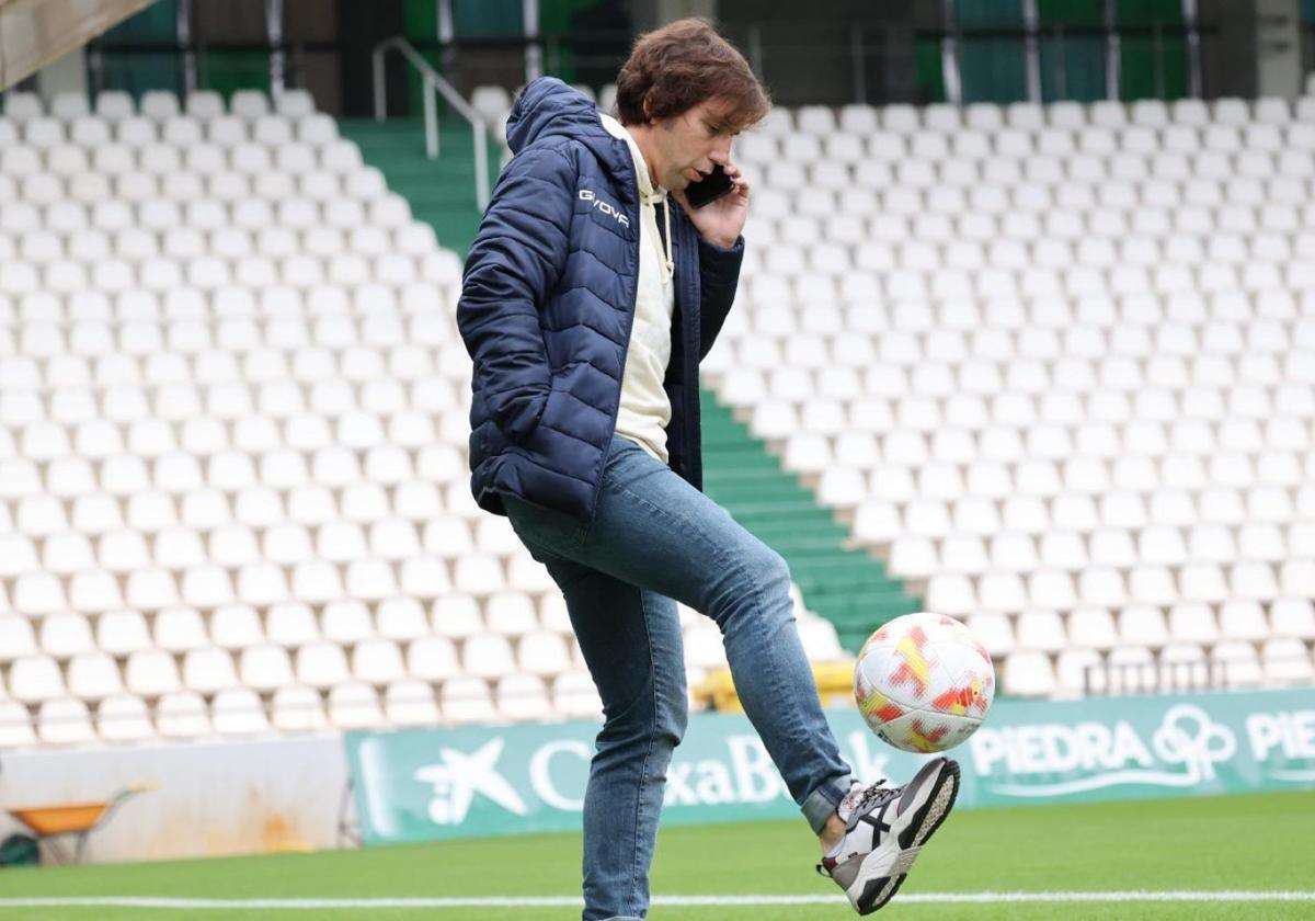 Raúl Cámara controla un balón mientras habla por teléfono en el campo del Córdoba.