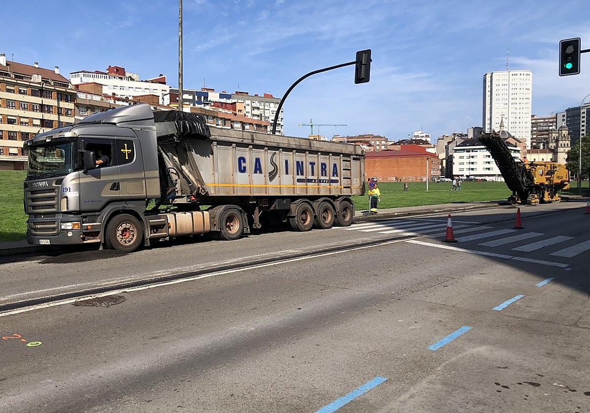 Un camión y una fresadora trabajan sobre el asfalto para hacer el nuevo carril-bici.