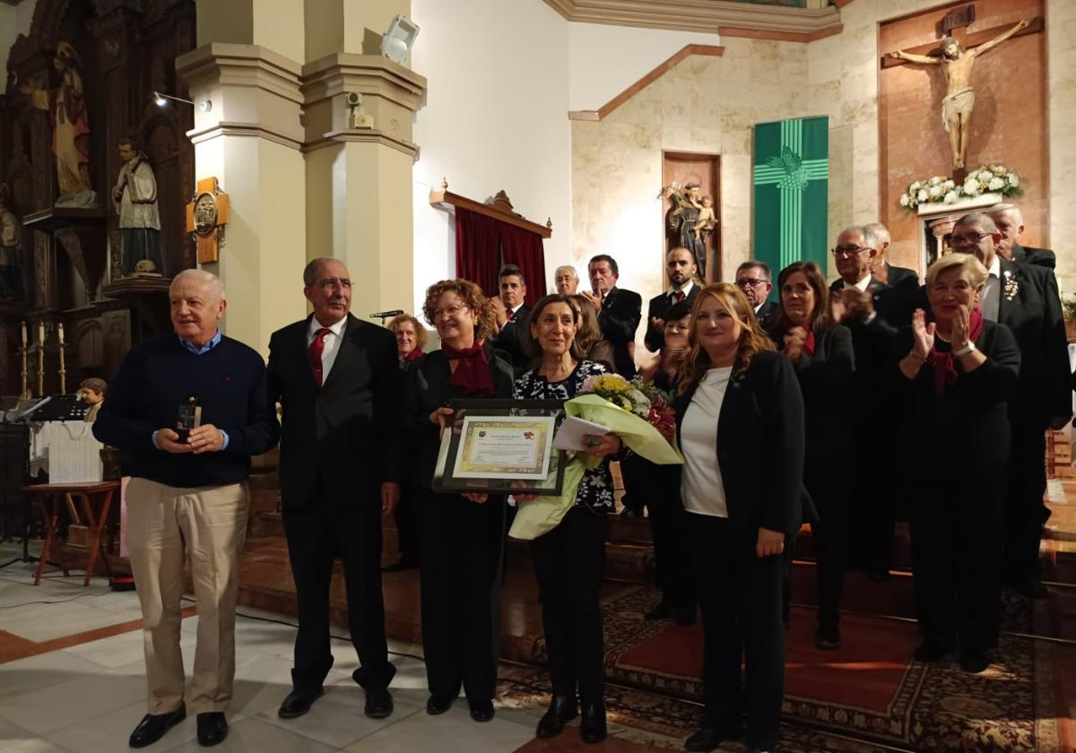 Juan Rodríguez y Raquel Fresno reciben la Avellana de Oro, acompañados por miembros de la Coral.