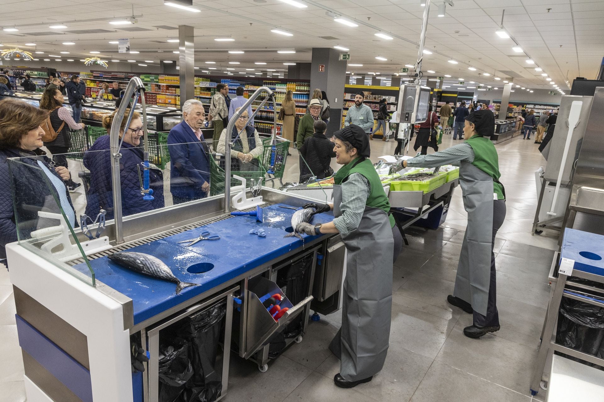 Trabajadoras de la sección de pescadería de Mercadona atienden a sus clientes.