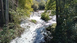 El río Nora, lleno de espuma, a la altura de la senda en su inicio en La Pola, ayer.