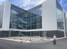 Exterior del inmueble judicial con zona para sentarse y árboles naturales.