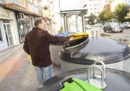 Un hombre deposita residuos en unos contenedores en Llanera.