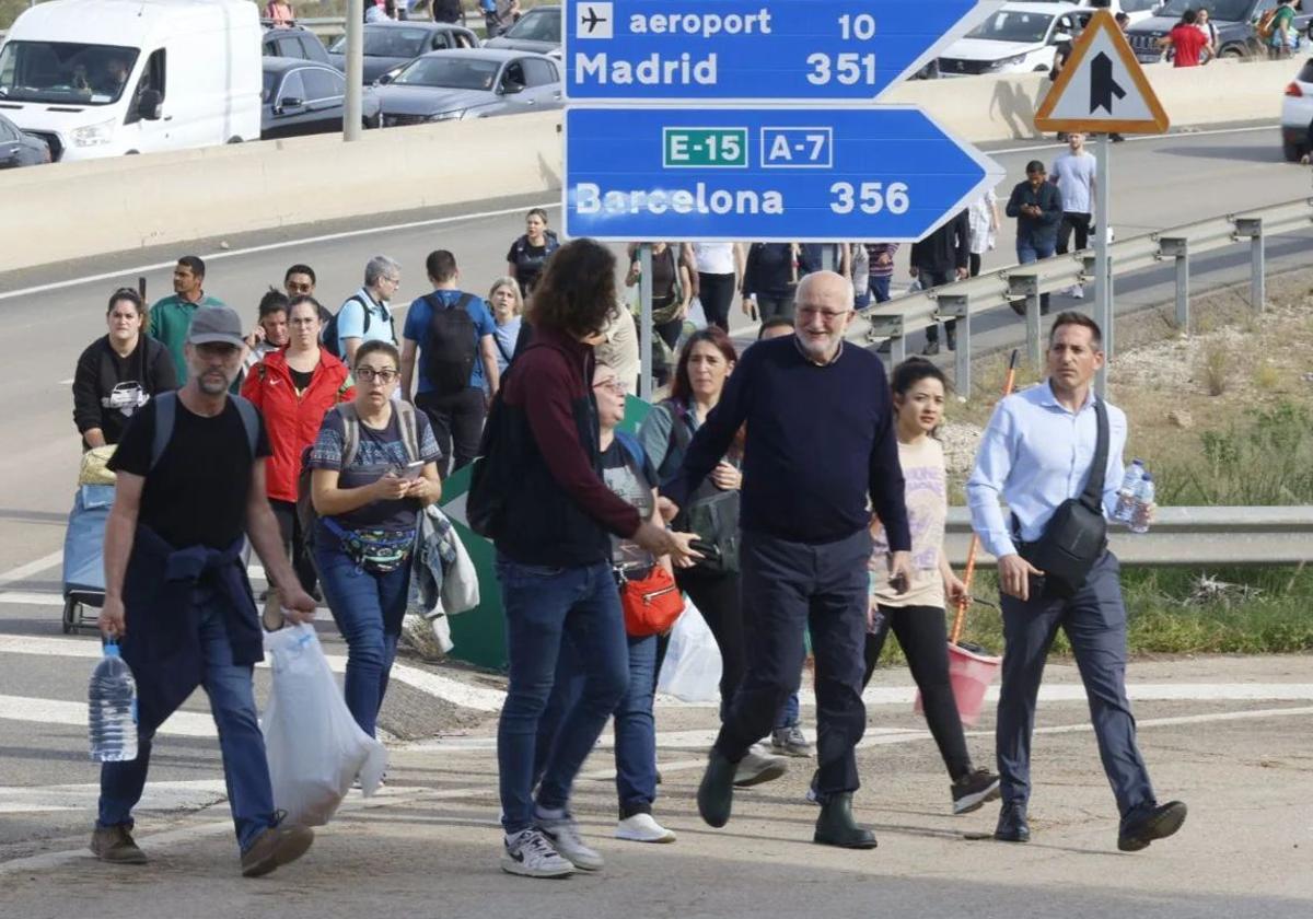 Juan Roig, dueño de Mercadona, camina con rumbo a Benetússer entre los cientos de valencianos que avanzan con ayudas para las víctimas.