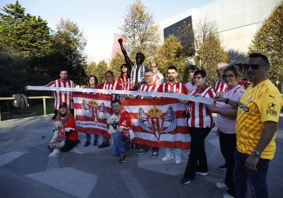 Miembros de la peña Sentimiento Rojiblanco-La Regence, ayer, posando para EL COMERCIO en la estatua de Quini, con El Molinón detrás.