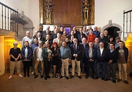 Trabajadores de Serenos Gijón posan con las autoridades en el altar de la antigua capilla.