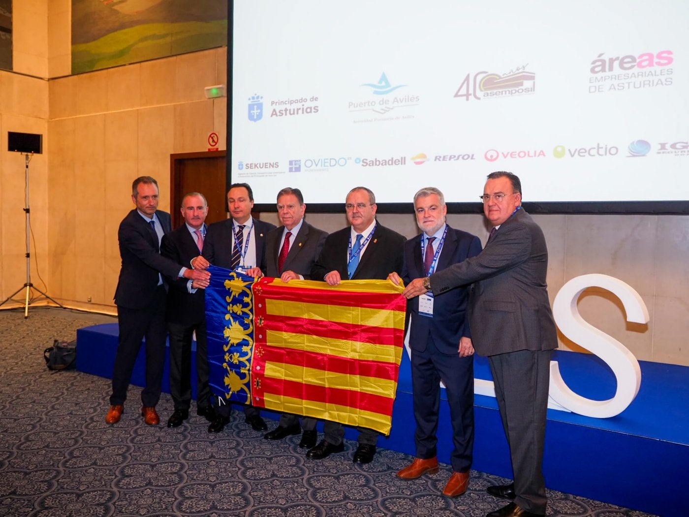 Representantes empresariales y políticos ayer, en Oviedo, con una bandera de la Comunidad Valenciana en apoyo a los afectados por la DANA.