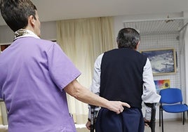 Una fisioterapeuta atiende a un paciente durante un proceso de rehabilitación.