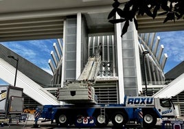 Una grúa eleva unos enormes focos sobre la entrada del hotel del Calatrava.