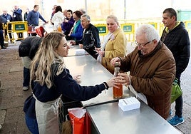 Un socio recoge la sidra en el mostrador de la carpa de la Sociedad Protectora de La Balesquida.