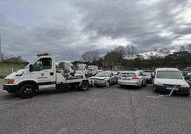 La grúa de la empresa de desguace retira uno del medio centenar de coches enajenados del depósito municipal poleso.