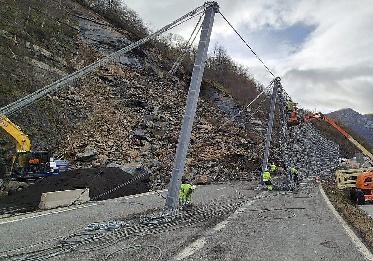 Los operarios trabajan en la colocación de la malla de contención en la ladera de la autopista del Huerna.