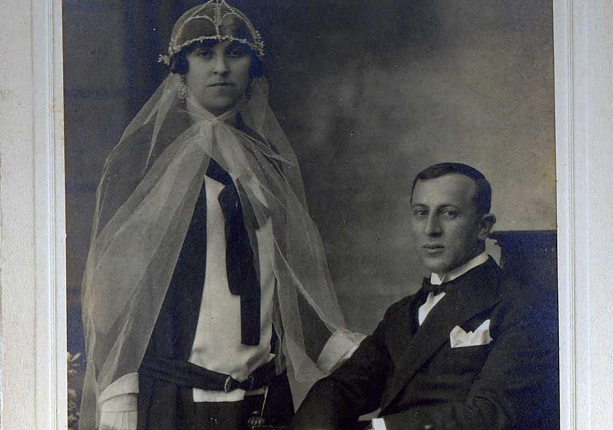 Retrato de boda de Encarnación Díaz Quintana y Casimiro López Bravo. Llamativo atuendo de boda en blanco y negro en el que el velo, que enmarca la cara al ir sujeto bajo la barbilla, la blusa y los guantes contrastan con el resto de piezas que forman este conjunto tan a la moda del momento. Fue tomada la foto por Ramón García Duarte, en 1927.