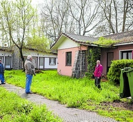 Vecinos de Perlora, junto a las casas abandonadas del recinto.