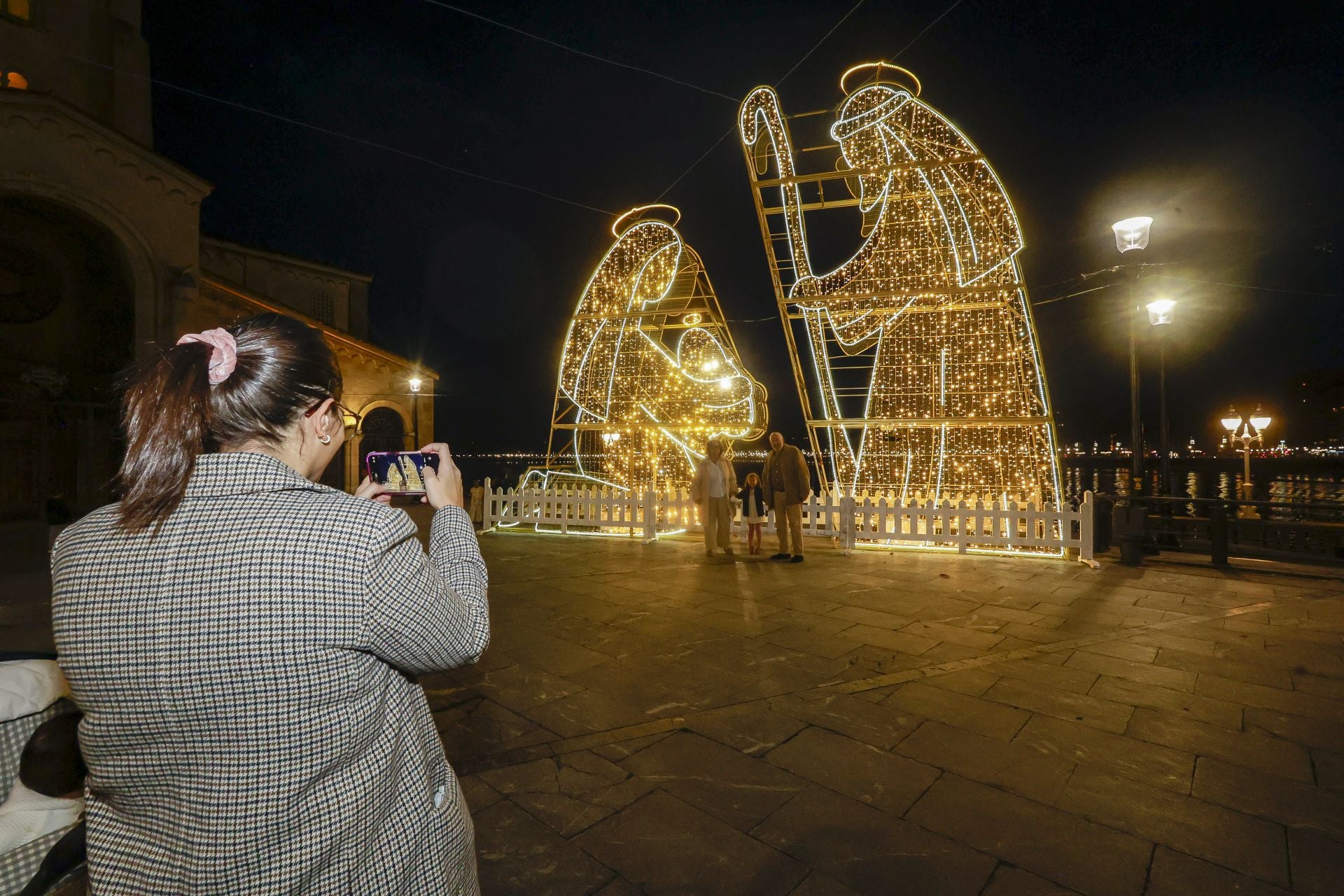 Una mujer fotografía las figuras tridimensionales del nacimiento, en el Campo Valdés.
