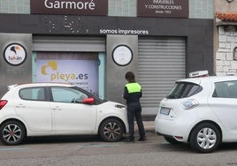 Un controlador de la zona azul, sancionando a un vehículo en Gijón.