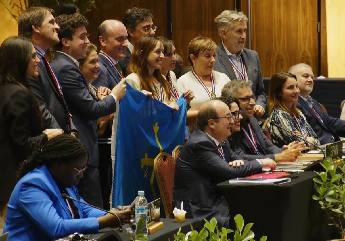 La delegación asturiana posea con una bandera asturiana tras la distinción de la UNESCO.