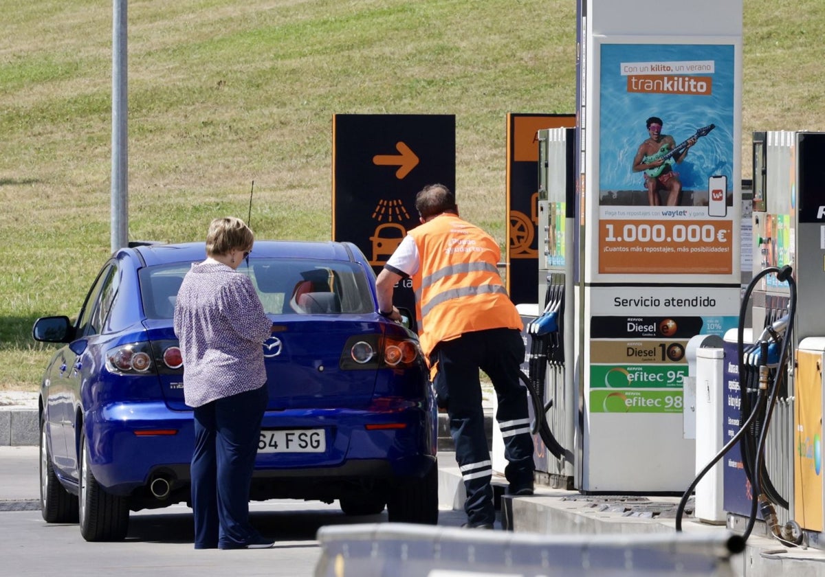 Una conductora reposta combustible en una estación de servicio.