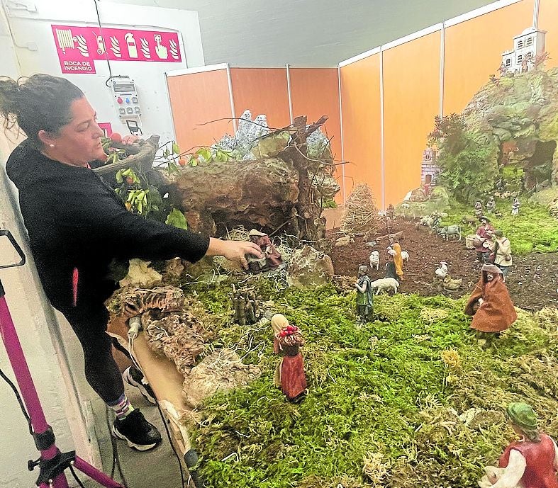 María Rodríguez coloca las figuras del portal.