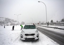 Los ocupantes de un vehículo se detienen en el área de descanso de Rioseco de Tapia, en la autopista del Huerna, para jugar con la nieve.