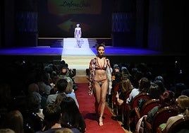 Una modelo, en la pasarela del patio de butacas durante el desfile de moda de baño 2025 de Dolores Cortés.