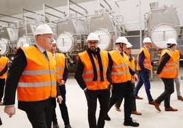 El CEO de Royal A-ware, Jan Anker; el alcalde de Salas, Sergio Hidalgo (detrás), y el presidente del Principado, Adrián Barbón, con el resto de autoridades y representantes de la láctea, en la visita a la fábrica de Salas.