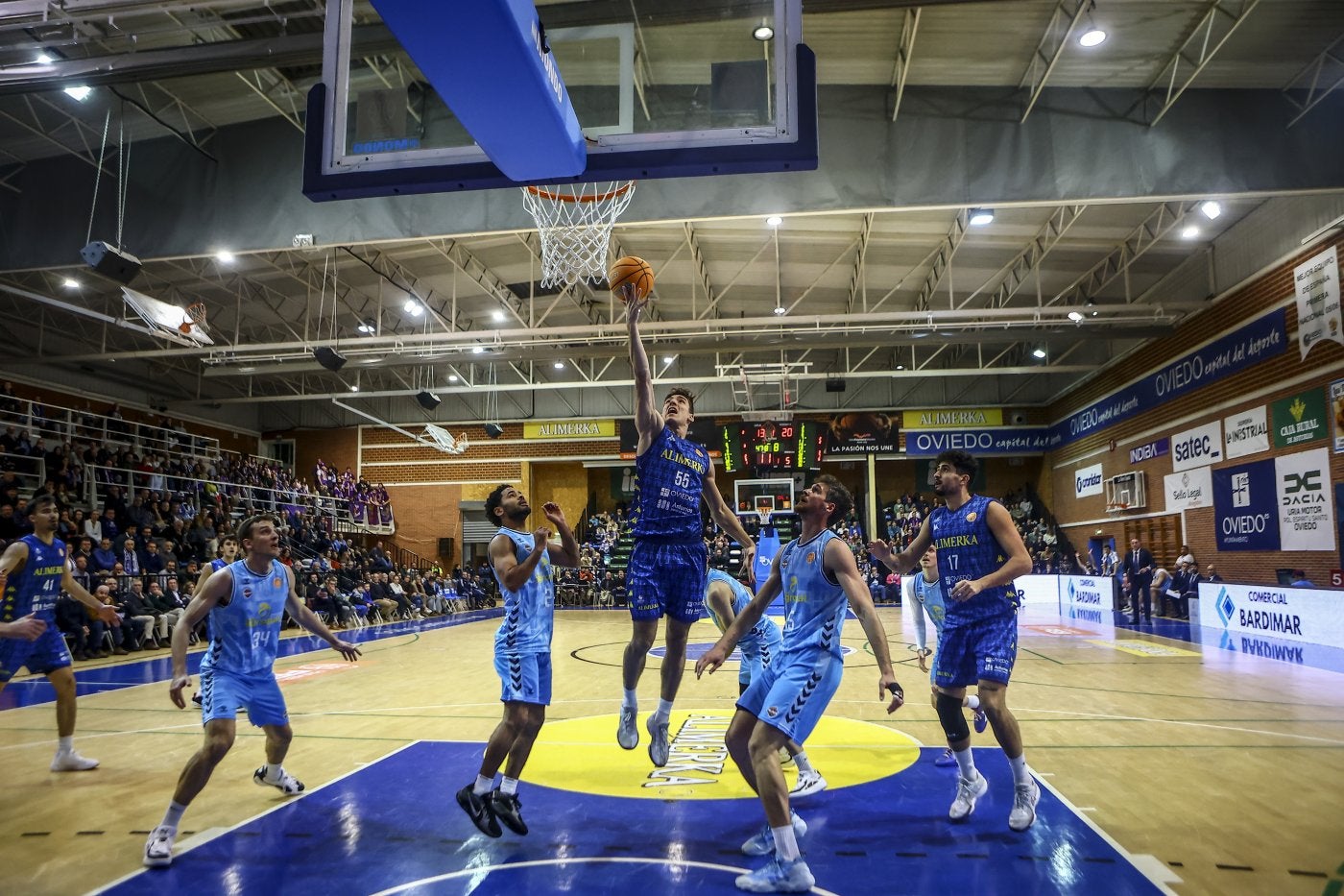 Raúl Lobaco, autor de once puntos anoche en Pumarín, entra a canasta rodeado de jugadores palentinos.