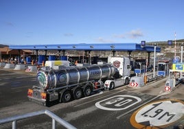 Un camión de transporte alimentario y una furgoneta industrial pasan por el peaje de La Magdalena, en la autopista del Huerna (AP-66).