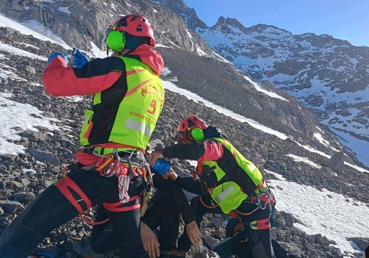 Dos efectivos del Servicio de Emergencias del Principado de Asturias atienden al joven al que se le buscaba en Picos de Europa.