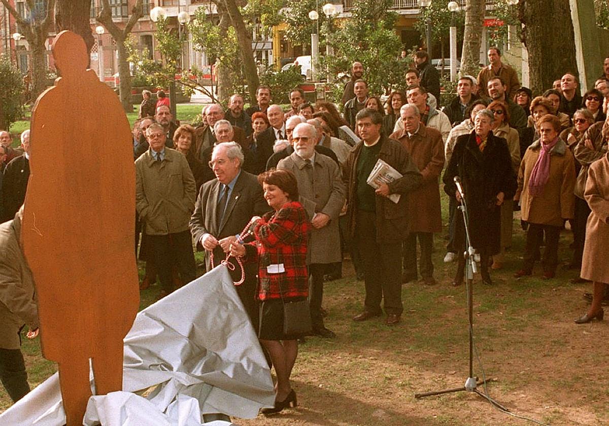 Areces y Paz F. Felgueroso en primer plano, con Camín detrás, descubriendo la 'Evocación' del artista en homenaje a Francisco Carantoña el 18 de diciembre de 1999, rodeados de familiares, periodistas y representantes de la vida social y cultural gijonesa.
