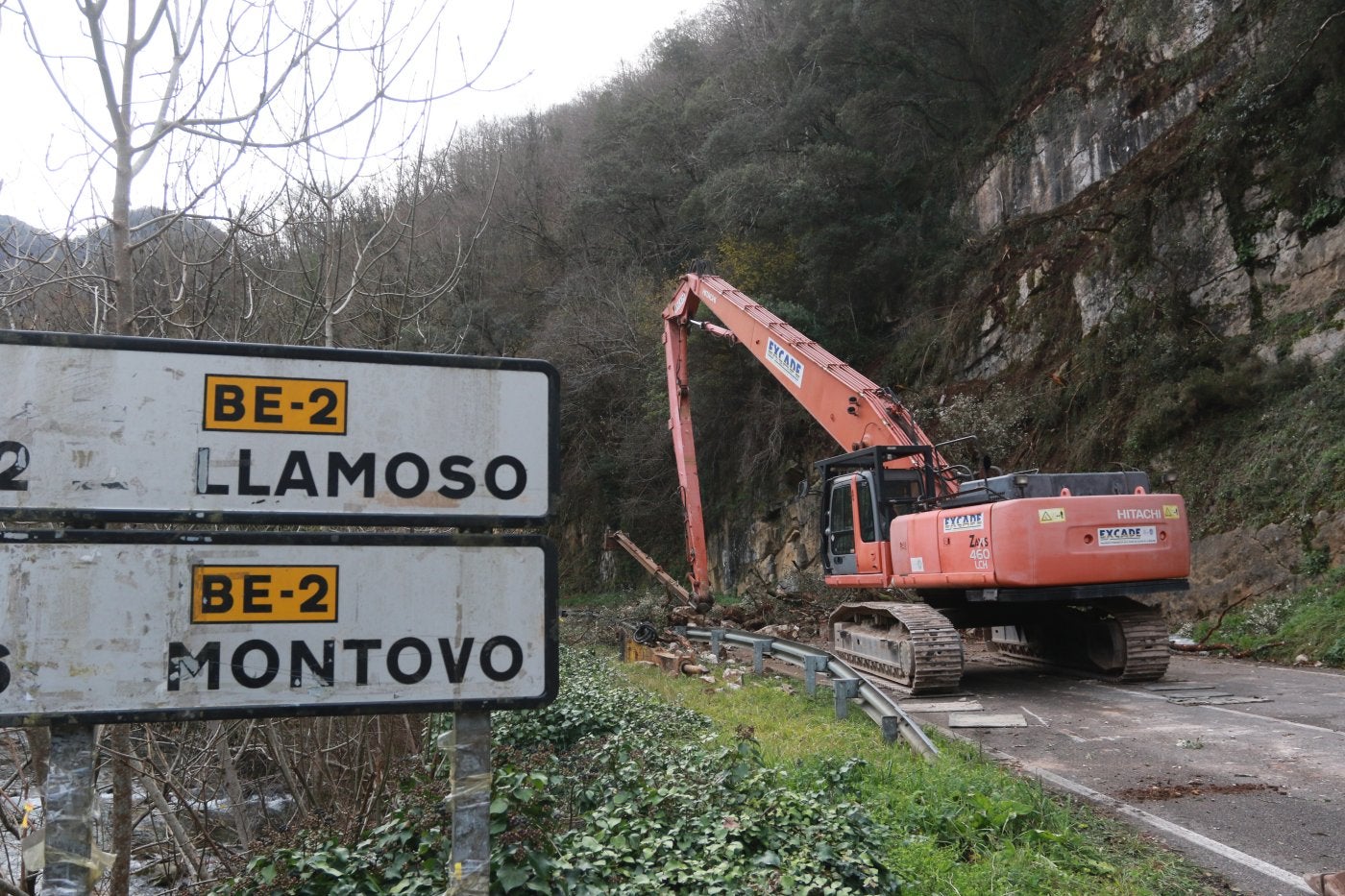 La excavadora que se encarga de retirar las rocas de ladera que amenazan con caer a carretera se prepara para efectuar los trabajos.