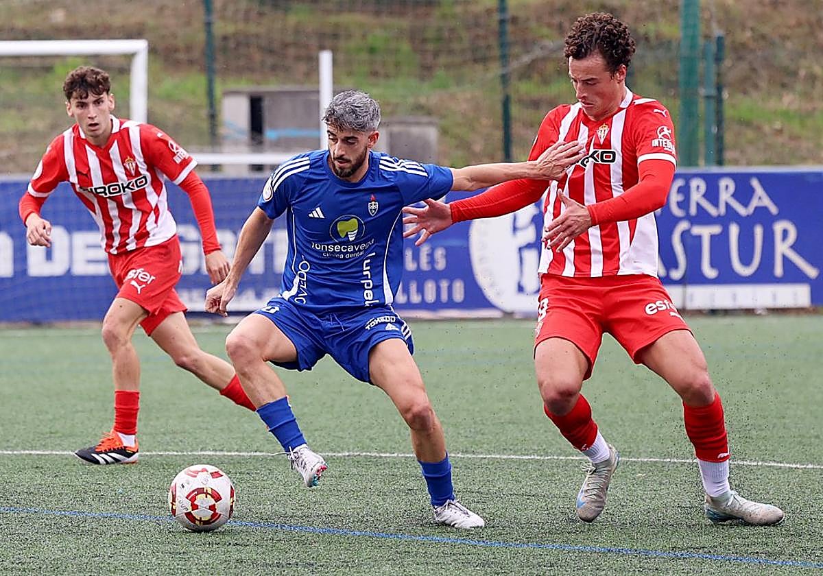 Esteban Lozano trata de frenar el avance de Miguel Secades en el partido entre el Sporting Atlético y el Covadonga.