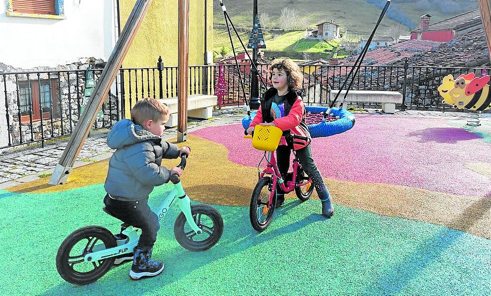 Sotres (Cabrales). Andrés y Haya, los hijos de Sara Fernández, juegan con sus bicicletas. e. c.