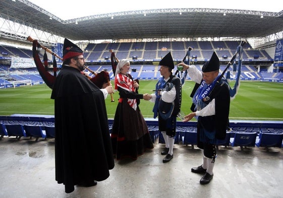 Vicente Prado 'El Pravianu' escancia sidra mientras José Luis García Díaz toca los acordes del himno de Asturias.En el centro de la imagen Paula García y José Manuel Fernández Gutiérrez 'Guti' se dan la mano amistosamente antes del derbi.