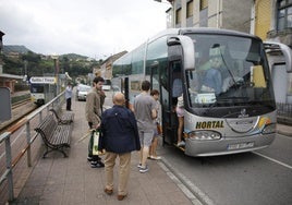 Usuarios suben a uno de los autobuses que en 2017 trasladaban a los viajeros en el valle del Nalón al tener que cortarse la línea por obras de mejora.