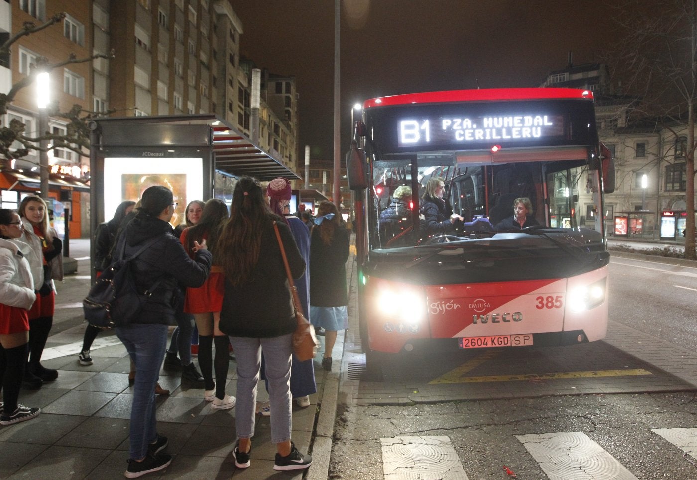 Pasajeros esperando a uno de los búhos que circulan actualmente por Gijón.